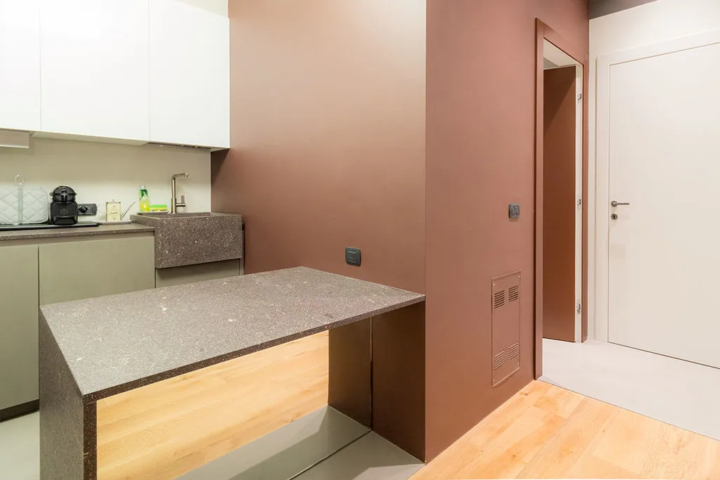 Piccolo angolo cucina in una zona di passaggio tra zona giorno e zona notte. Cucina con frontali in micro-malta viola